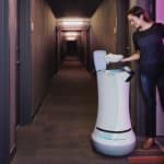 Imagen del robot mayordomo Savioke en un hotel junto con un cliente o huésped